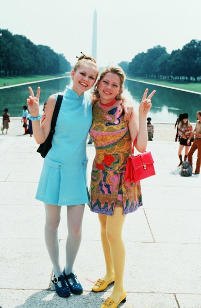 Betsy and Arlene wear colorful minidresses and tights paired with platform shoes.
