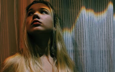 Young woman against curtain