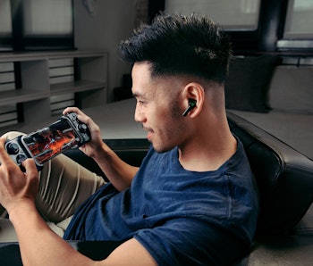 A man uses the Razer Kishi to play a game on his iPhone.