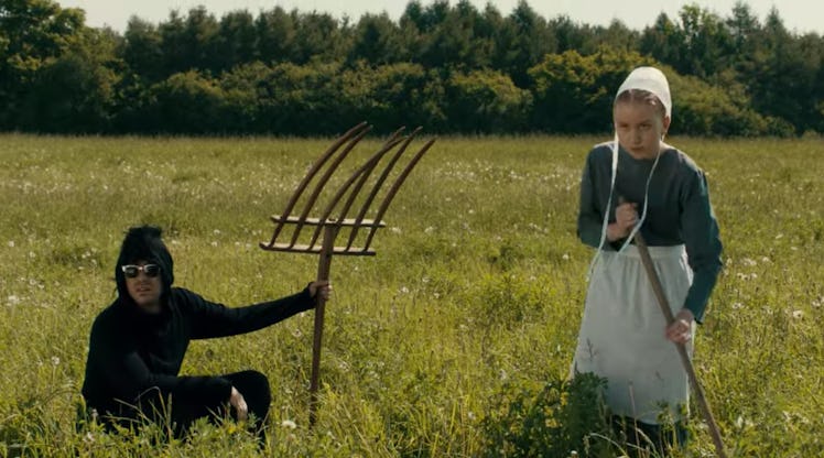 David (Dan Levy) sits in a field with an Amish girl on 'Schitt's Creek.'