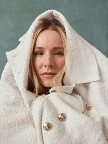 Kristen Bell wrapping the white Chanel coat over her head 