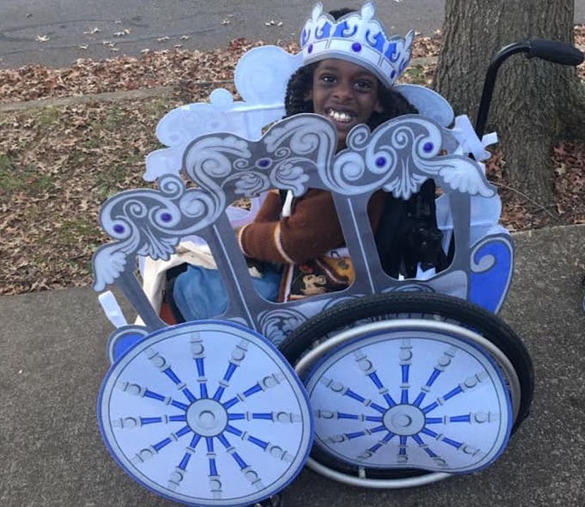 A smiling little Black girl in a Cinderella costume that turns her wheelchair into Cinderella's magi...