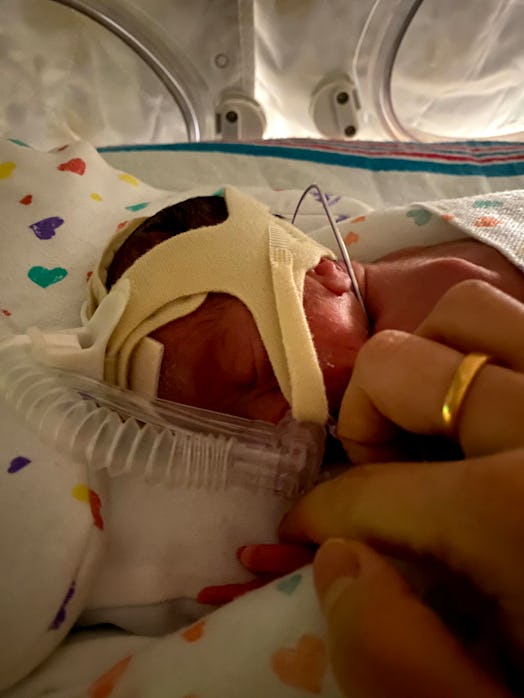 27 week old premature baby in isolette, holding mom's finger
