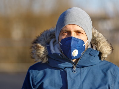 Man wearing a mask and warm clothing.
