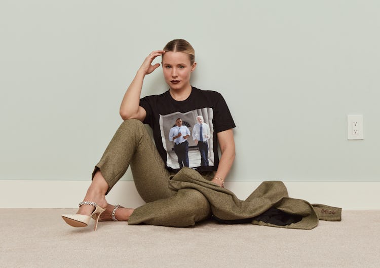Kristen Bell posing on the floor in a Brandon Maxwell jacket and pants, Jimmy Choo shoes and a tee w...