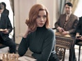 Beth (Anya Taylor-Joy) sits at a table with a chess game before her in 'The Queen's Gambit.'