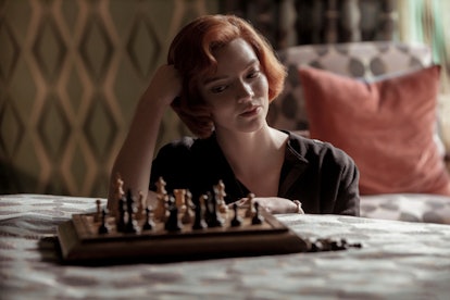 Beth Harmon (Anya Taylor-Joy) sits at a chess board on a bed in 'The Queen's Gambit.'