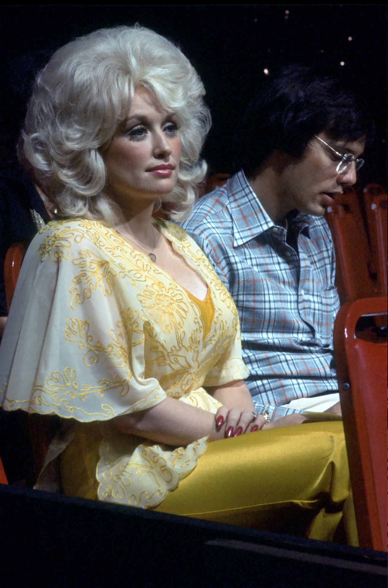 Dolly Parton with blonde hair and a yellow outfit in 1975.