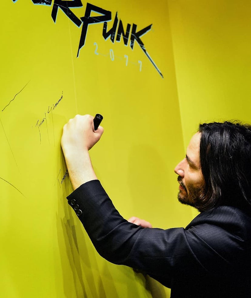 Keanu Reeves autographing a wall for Cyberpunk 2077.