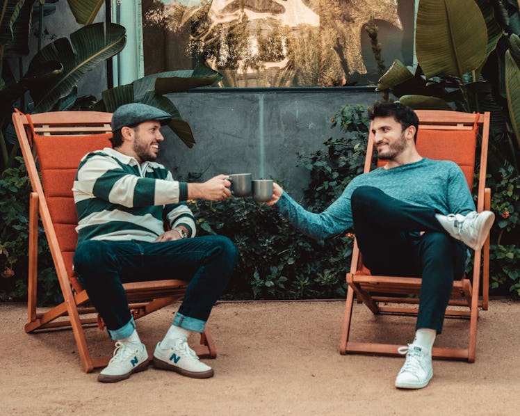 Vlog Squad’s Zane and Heath sit in chairs and toast their coffee mugs while promoting their new bran...