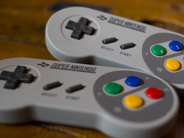 Two grey Nintendo Switch controllers placed next to each other on a wooden surface