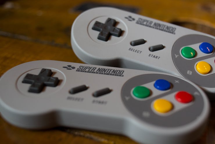 Two grey Nintendo Switch controllers placed next to each other on a wooden surface
