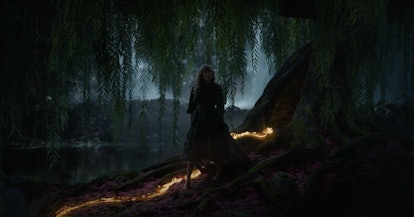 Taylor Swift walks in the woods at night along a gold lava trail in the "willow" music video.