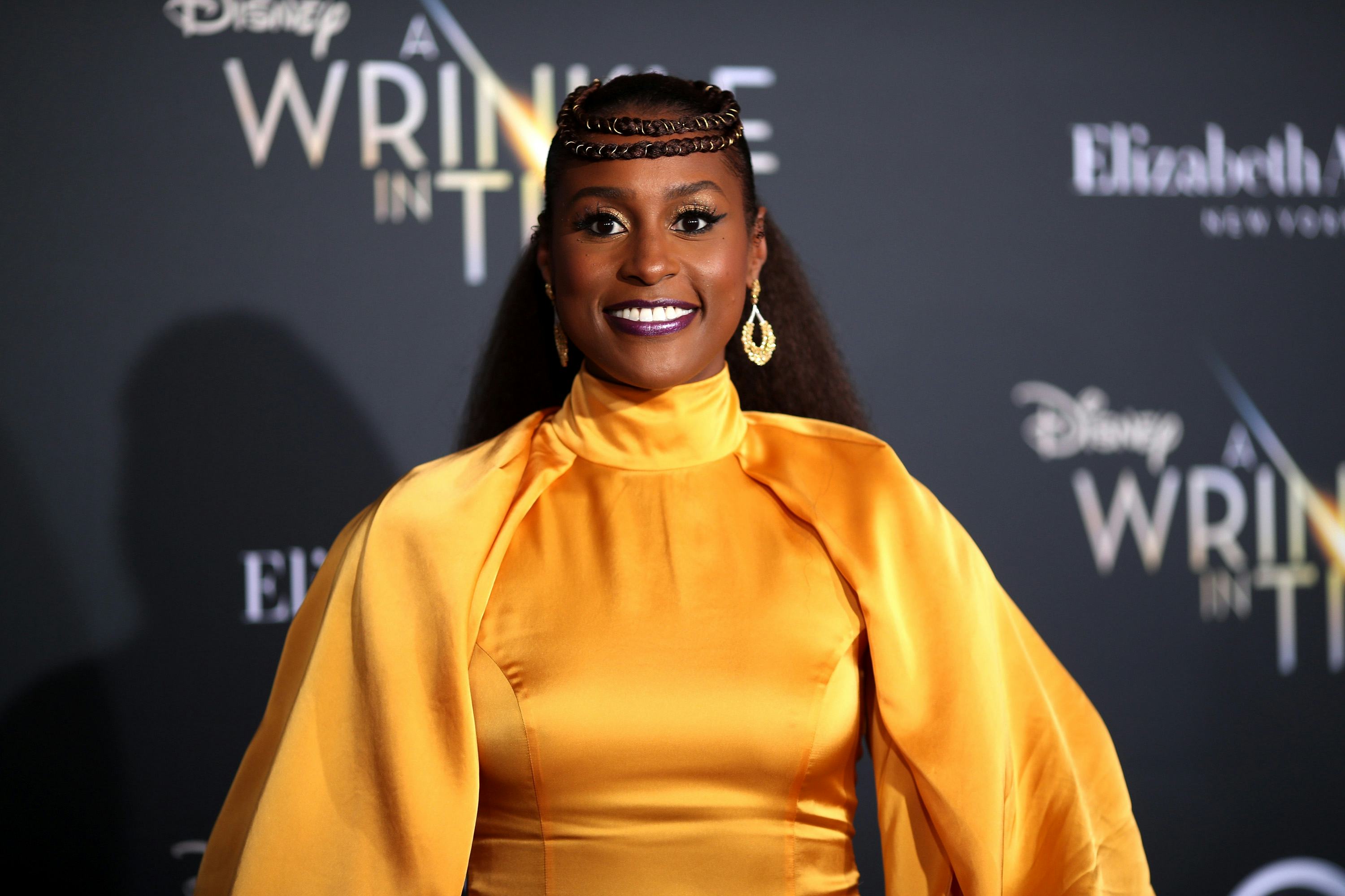 Issa Rae wears a yellow dress at the premiere red carpet for A Wrinkle In Time