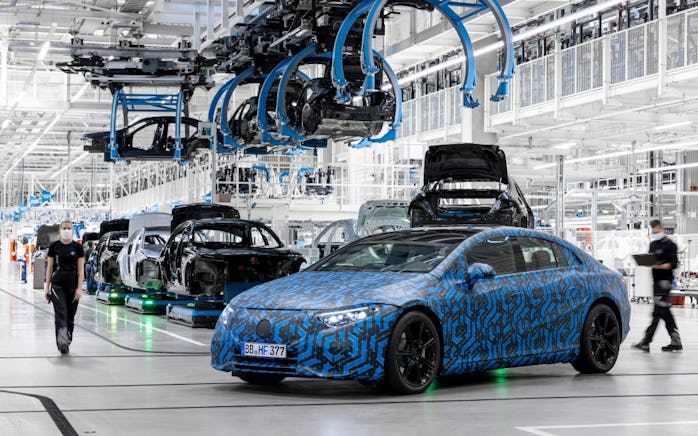 Prototype of the Mercedes-Benz EQS electric sedan parked in a manufacturing plant. 