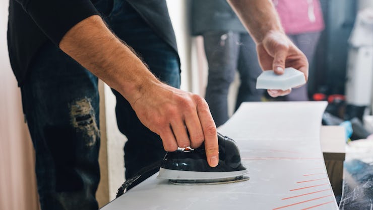 A man applying the right wax on his snowboard