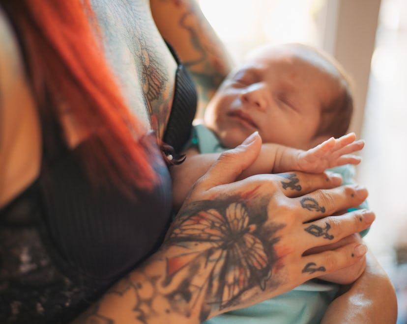 tattooed mom holding newborn infant