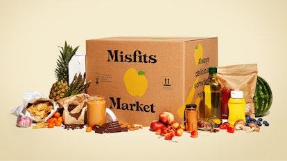 A Misfits Market box, with produce and goods surrounding it.