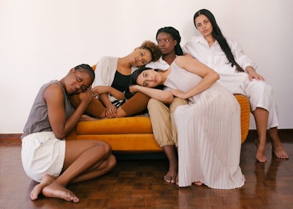 A group of 5 women sitting and leaning while posing on a couch together from We Are Renn
