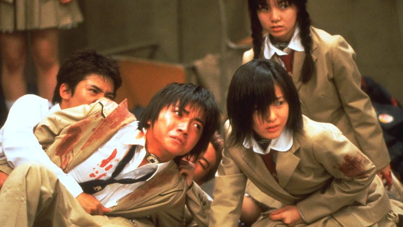 Scene of four cast members from the Battle Royale movie having worried faces
