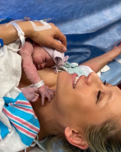 Anna Kournikova cradles her newborn daughter shortly after her birth while laying in a hospital bed....