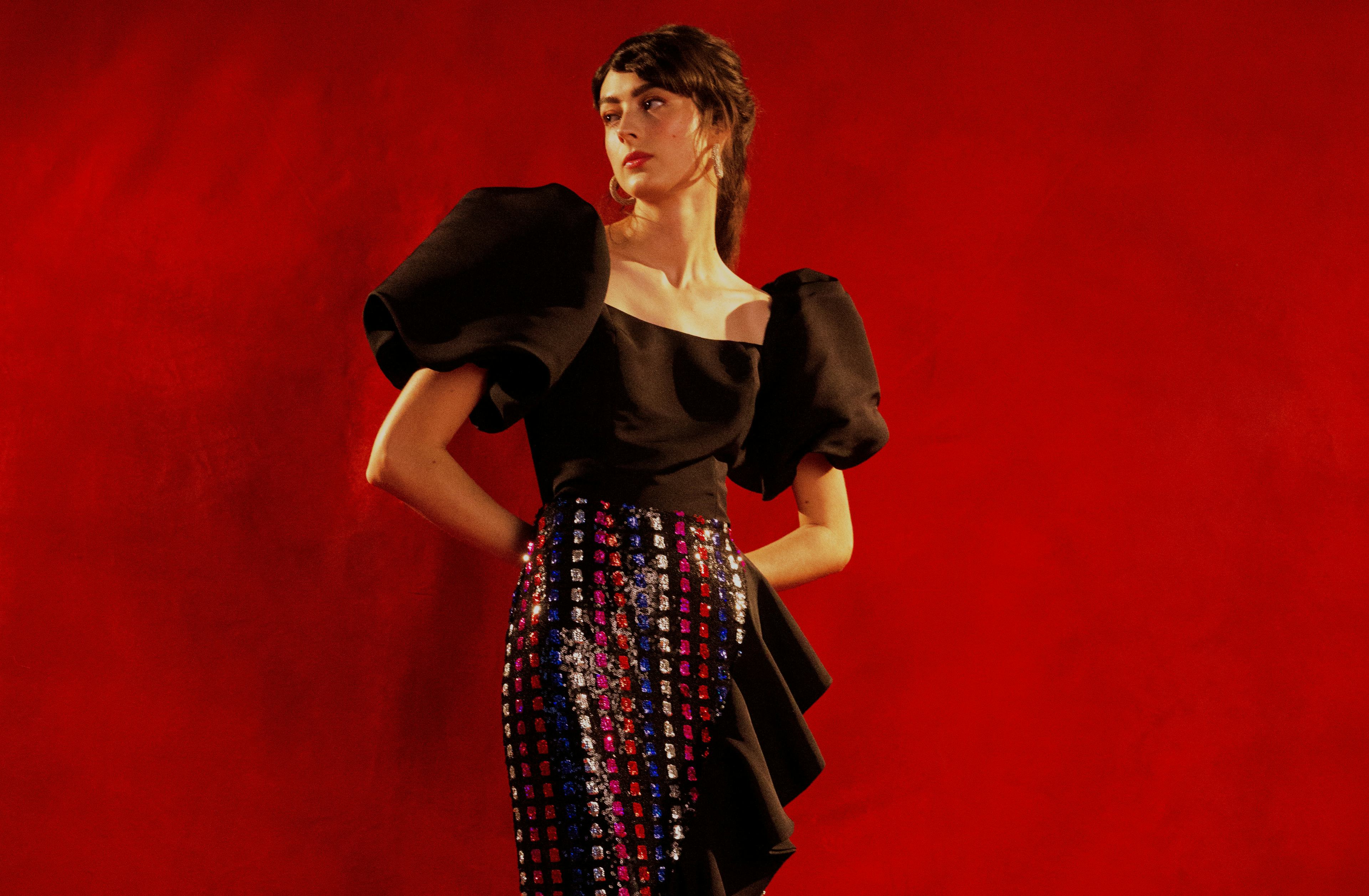 A model wearing a black top with puffer sleeves and a skirt by Markarian