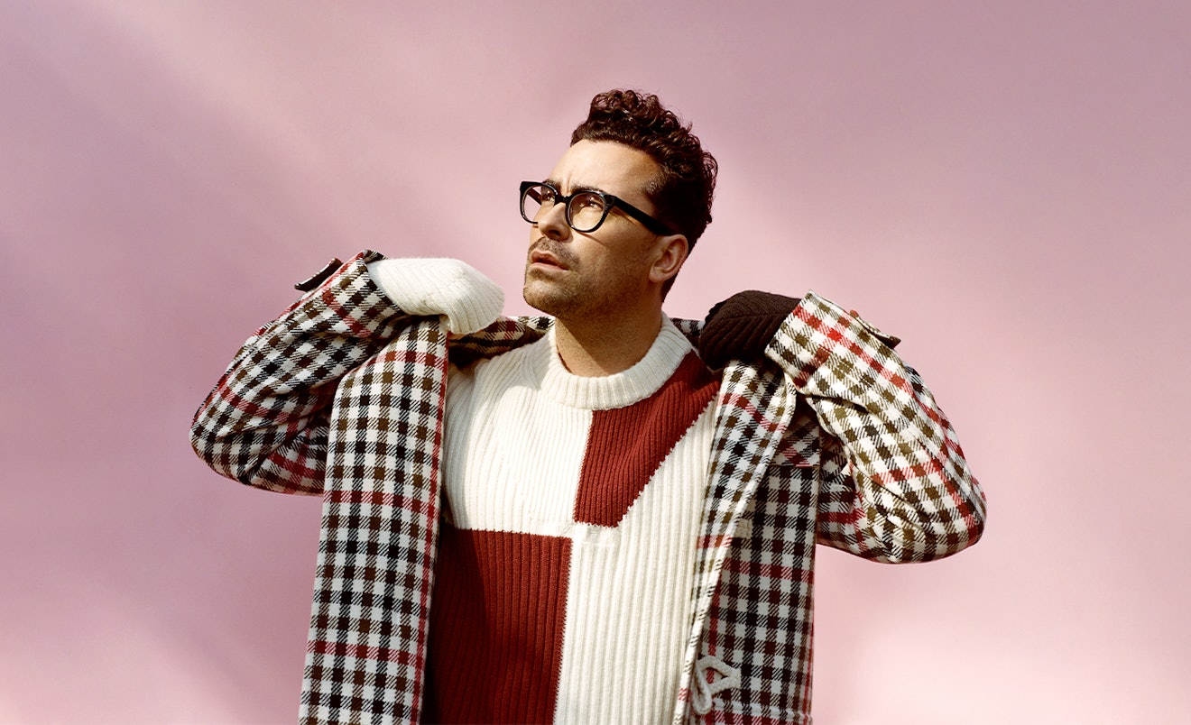 Dan Levy in a plaid JW Anderson coat and a red and white GmbH sweater 