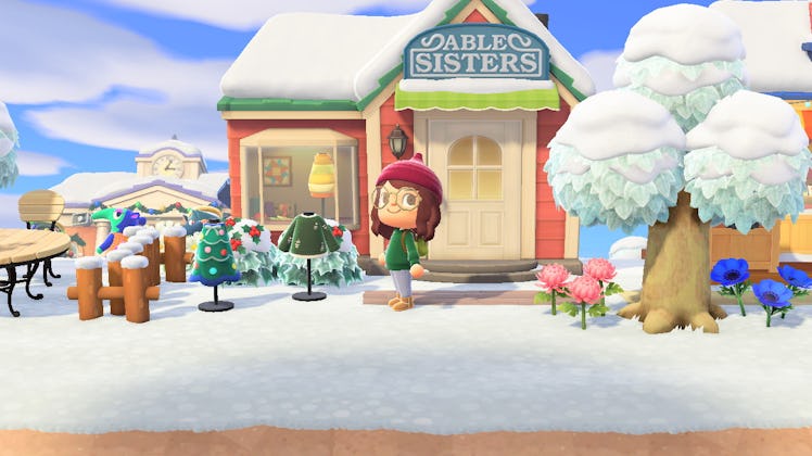A girl character poses in front of Able Sisters in an Animal Crossing winter.