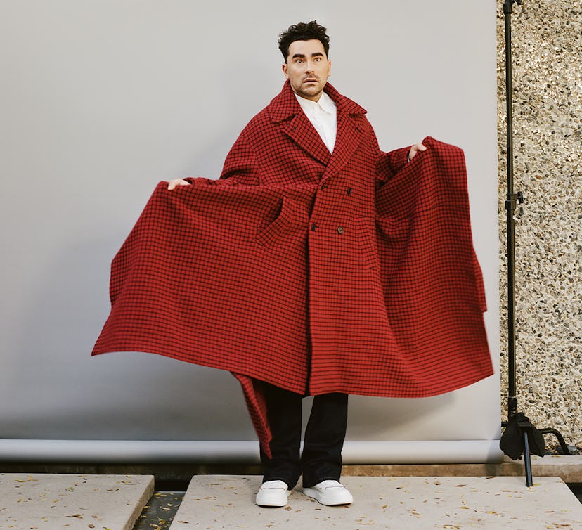 Dan Levy in a red JW Anderson coat and white sneakers shoes