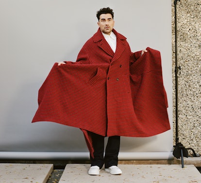 Dan Levy in a red JW Anderson coat and white sneakers shoes