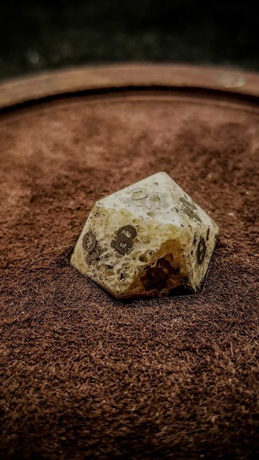 A d20 made from human bone by Artisan Dice in Dallas Texas