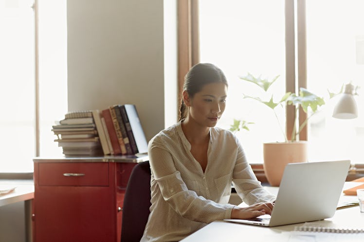 Young woman typing on laptop