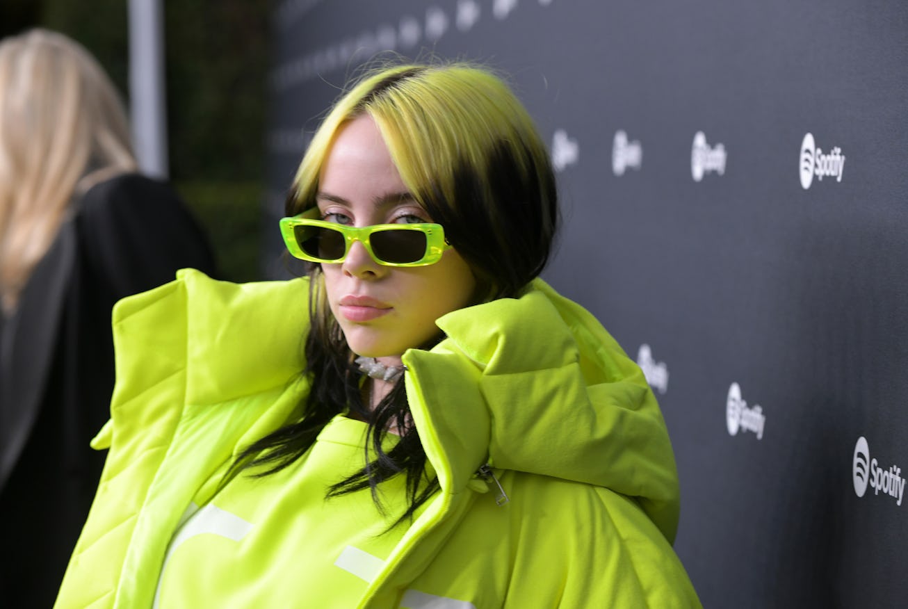 Billie Eilish with green hair and a matching puffer jacket