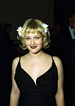 Drew Barrymore with short blonde hair and bangs in the '90s.