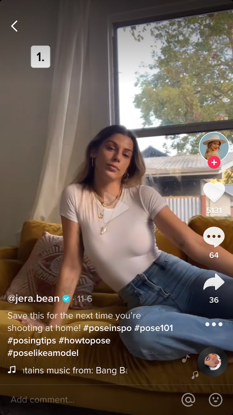 A woman poses on her couch for a selfie at home.