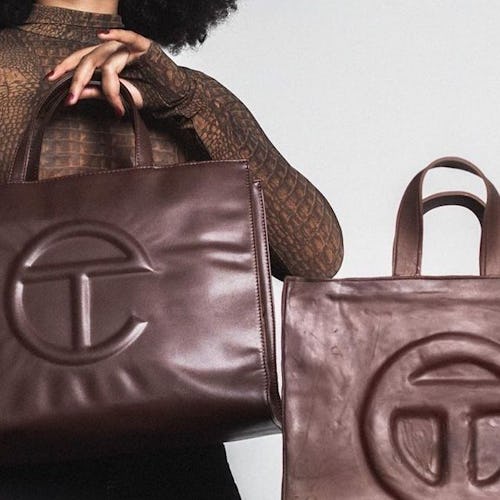 A woman in a brown turtleneck holding up a leather Medium Chocolate Shopping Bag from Telfar