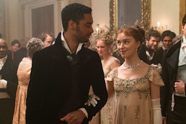 Simon and Daphne look at each other whole attending a ball in 'Bridgerton'.