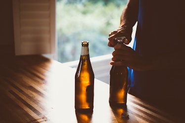 Man opening up a new beer bottle.