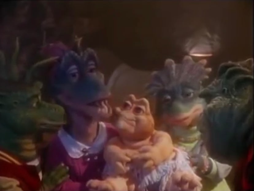 The puppet cast of 'Dinosaurs' gathers around their new baby.