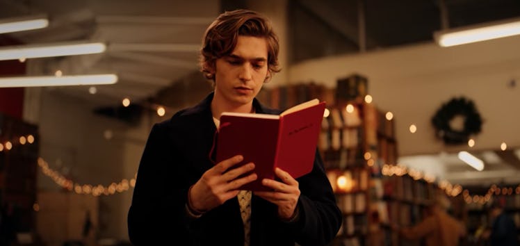 Dash from 'Dash & Lily' looks at a red notebook in the Strand Book Store in New York City. 