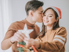 Asian couple hanging Christmas tree star