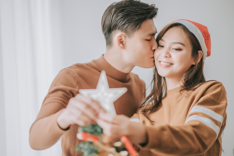 Asian couple hanging Christmas tree star