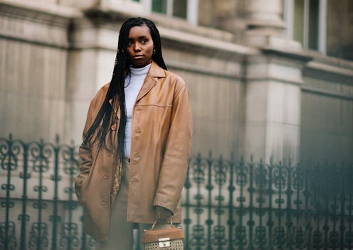 A woman in a caramel winter coat, sweatpants and a caramel purse