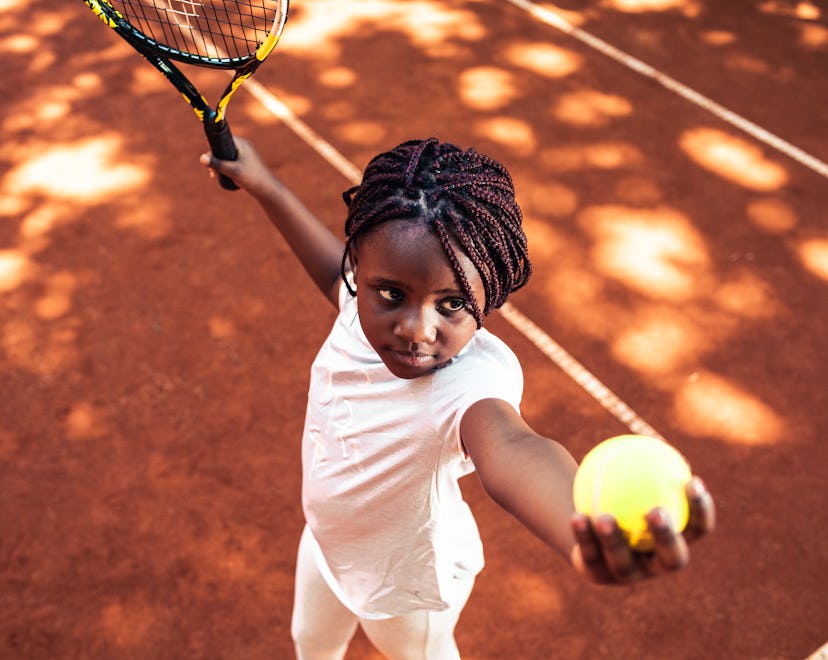 Child serving tennis ball
