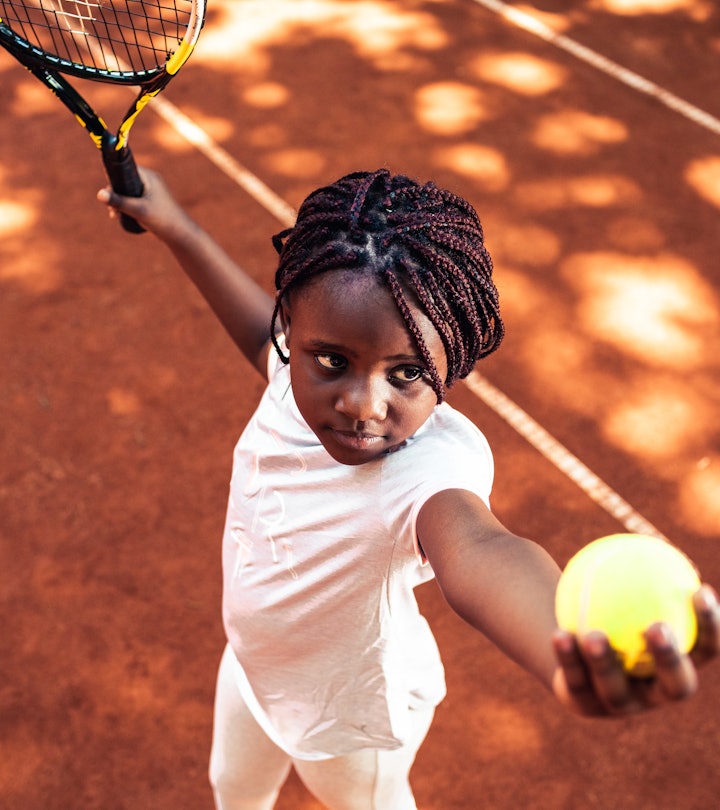 Child serving tennis ball