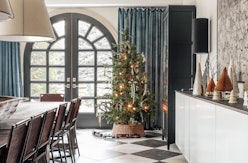 A dining room decorated for the holidays with a christmas tree in the corner