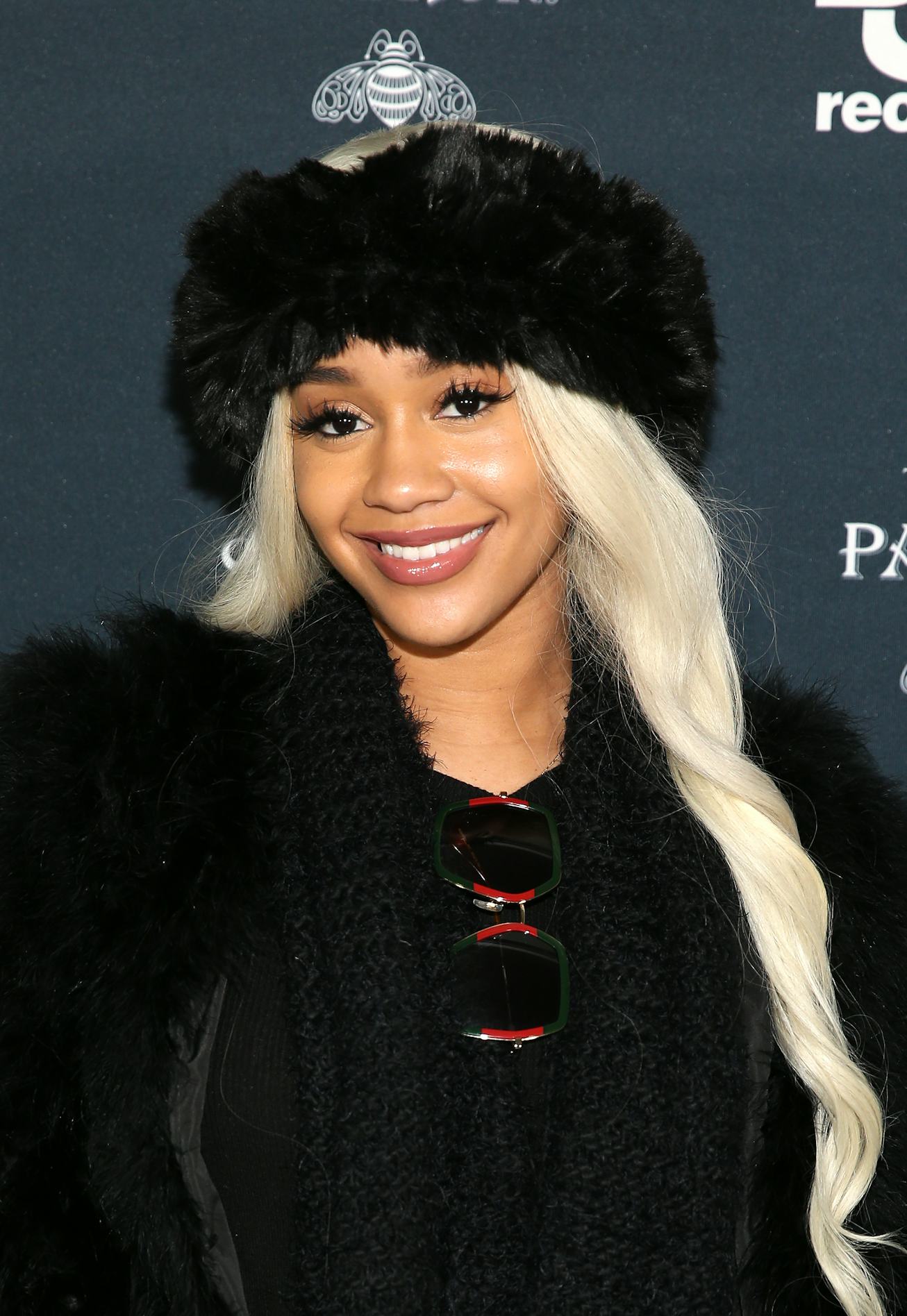Rapper Saweetie with long platinum blonde hair and winter hat.