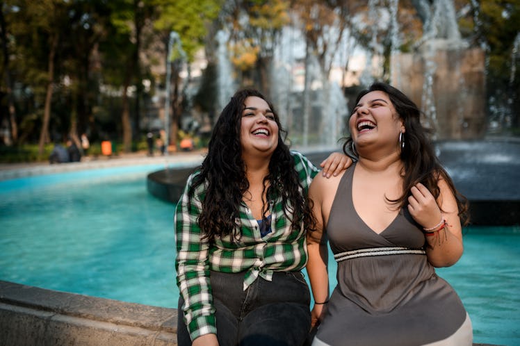 Sisters sitting by fountain