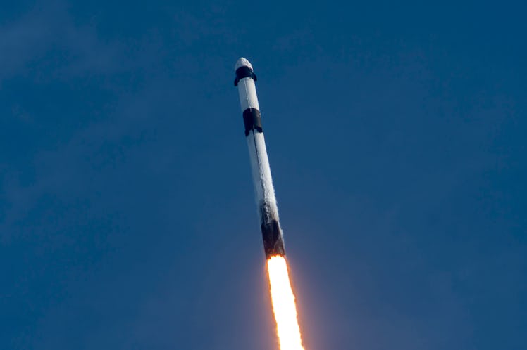The rocket rising into the sky.