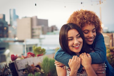 Friends hugging on urban rooftop